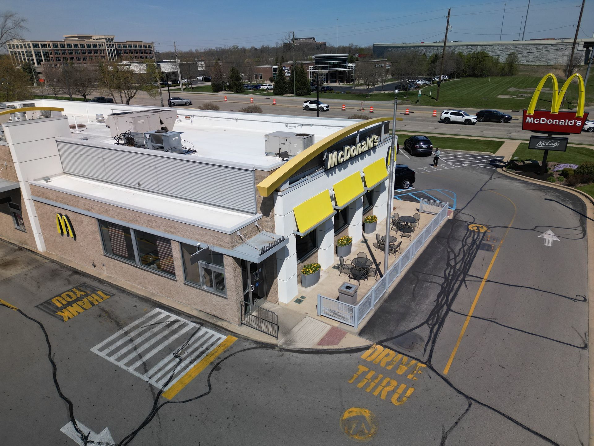 McDonald’s restaurant with drive-thru lanes, seen from above on a street corner.