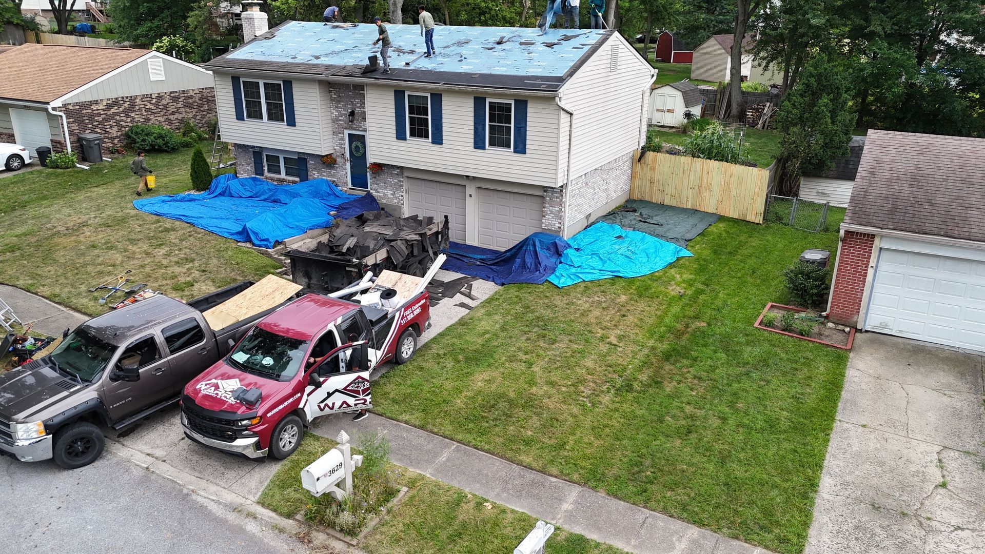 Workers perform a roof replacement on a suburban house in Indianapolis